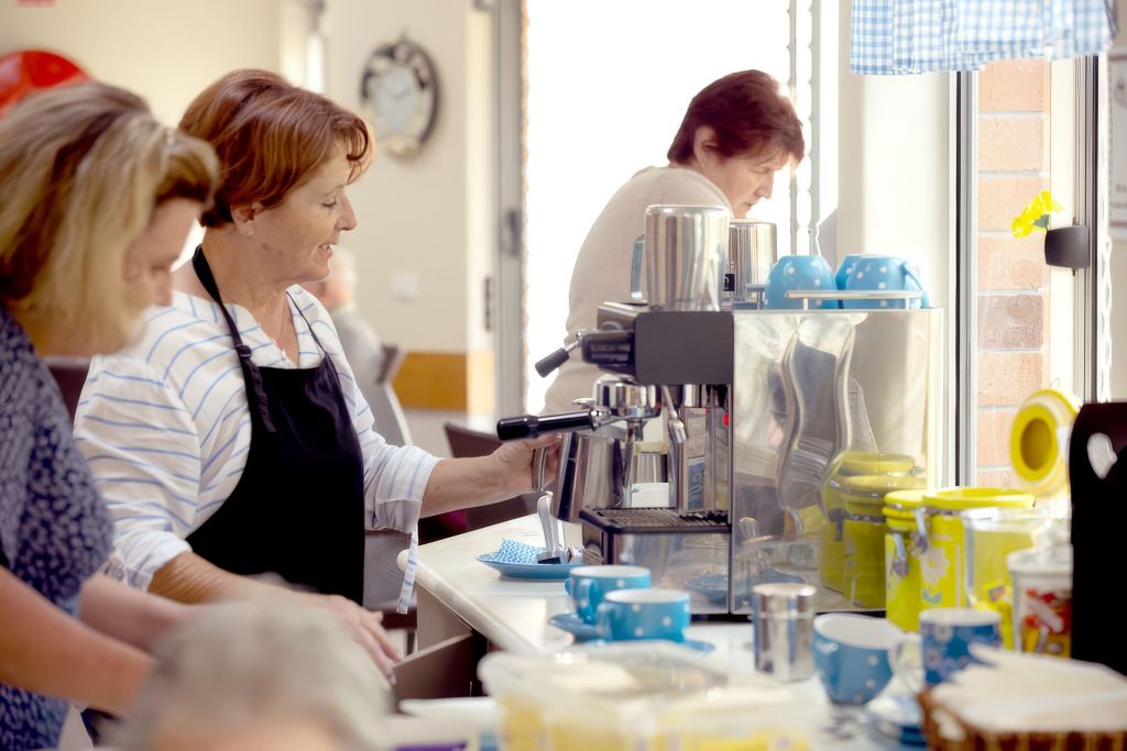 Residents and staff preparing food together in the kitchen